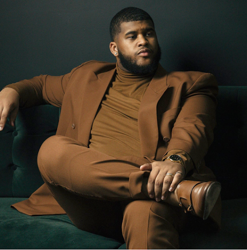 Big guy wearing a brown suit 